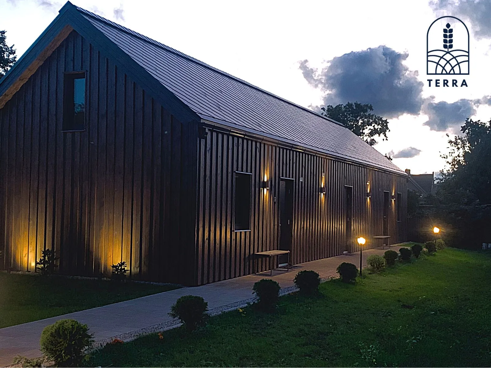 Terra House at dusk with the path lights on