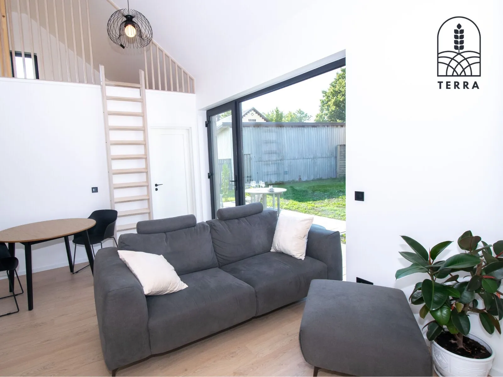 Living room with the sofa and the garden doors, apartment 2 — Terra House, Ventspils